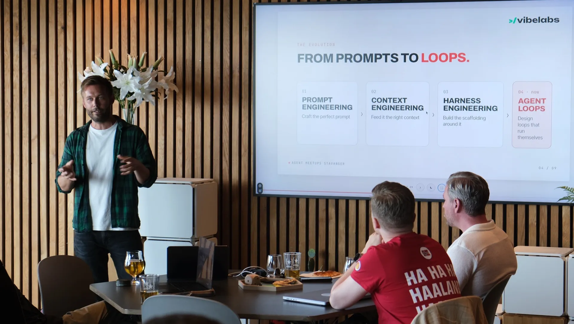 Christian von Hanno presenting the slide “From prompts to loops” at an agent meetup. The screen shows four steps: prompt engineering, context engineering, harness engineering and agent loops.